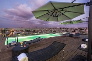 Una piscina al aire libre, sillones reclinables de piscina