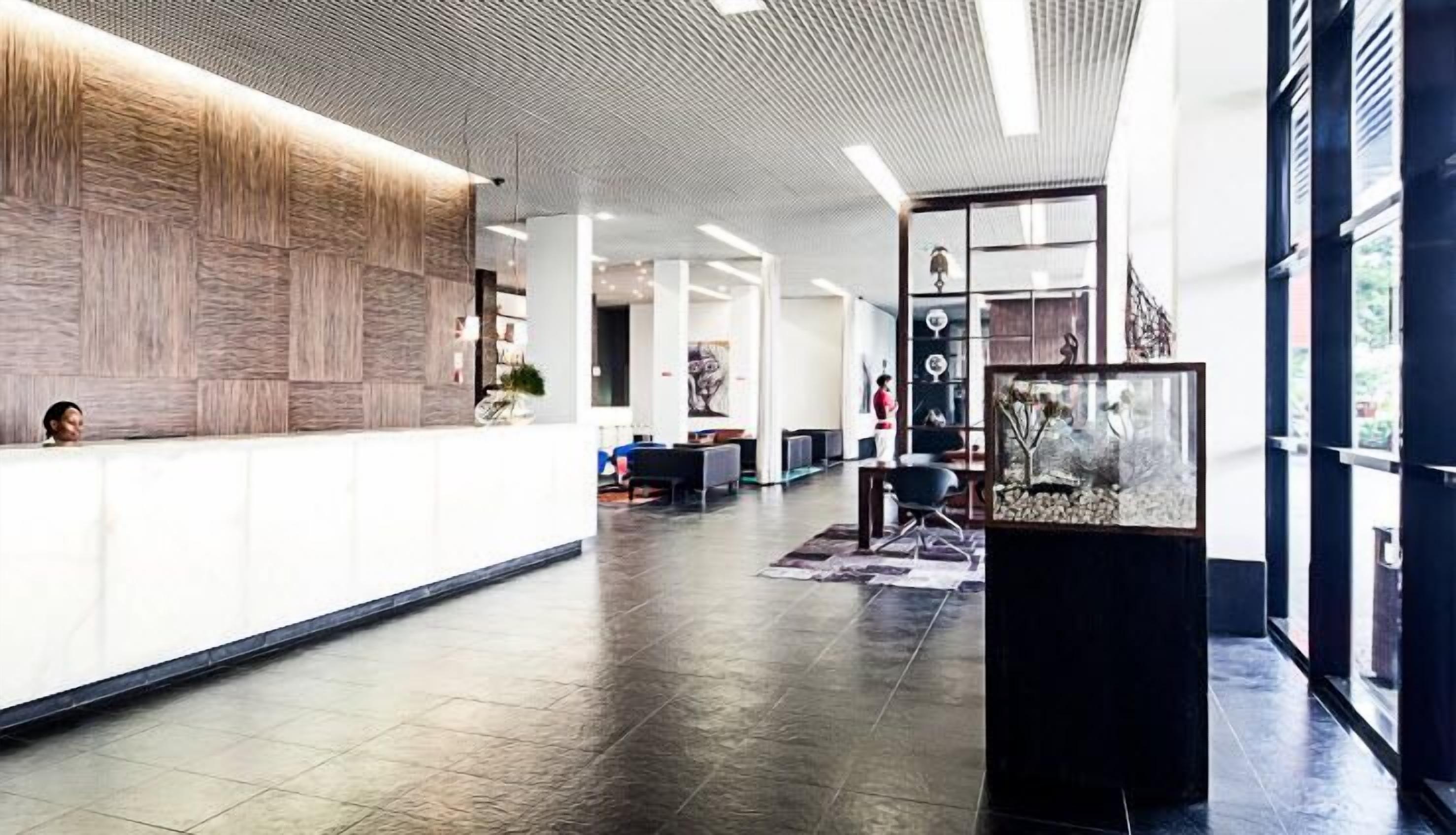 A spacious lobby with a reception desk, seating area, and a large aquarium.