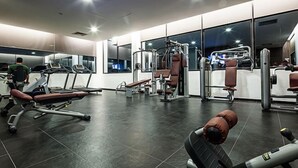 A gym with treadmills, weight machines, and benches.