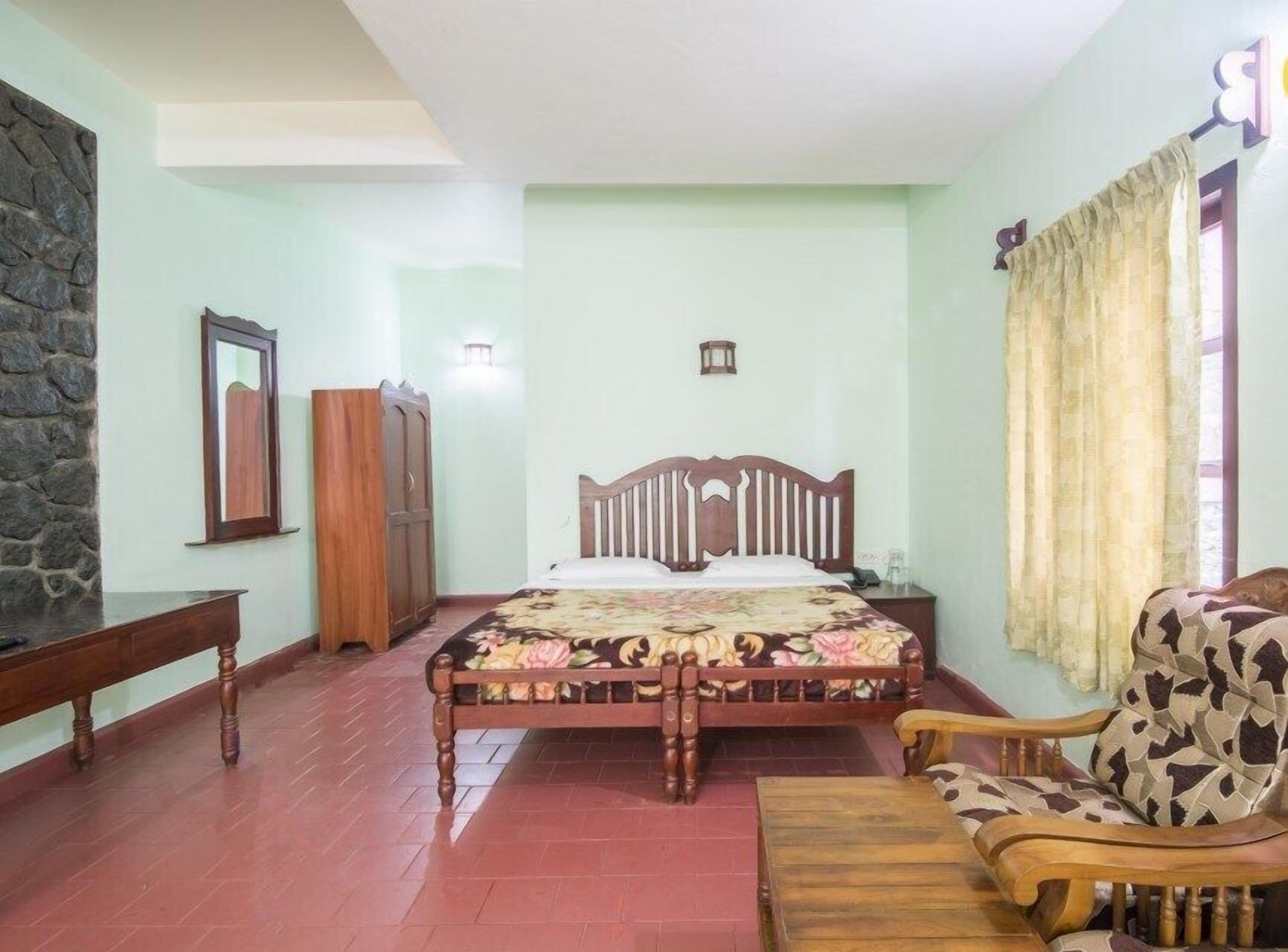 A bedroom with a wooden bed, a wooden chair, a nightstand, and a wardrobe.