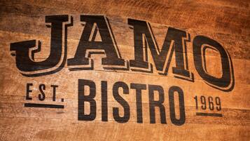 A wooden sign with the text "JAMO EST. BISTRO 1969".