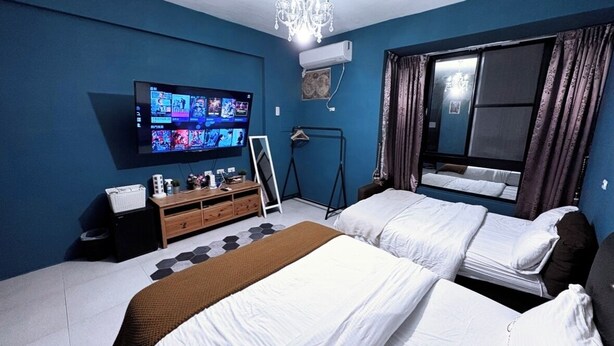 A hotel room with two beds, a TV mounted on the wall, a chandelier, and a window with curtains. - Kenting Timehouse (Hengchun)