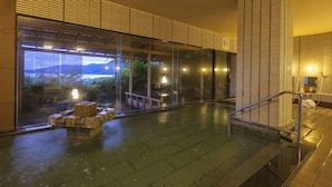 A modern indoor pool area with a view of the mountains and a bench. - Wajimaonsen Yashio (Wajima)