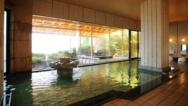 A modern indoor pool area with clear glass walls, a tiled floor, and a wooden ceiling. - Wajimaonsen Yashio (Wajima)
