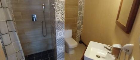 A bathroom with a shower, toilet, and sink.