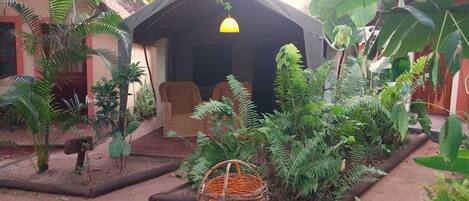 A covered outdoor seating area with a chair and a basket.