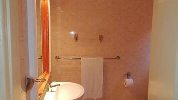 A bathroom with a sink, mirror, towel rack, and toilet.