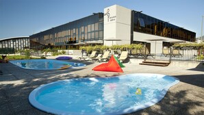 A modern building with a swimming pool area featuring inflatable pools and lounge chairs. - Riviera Palace Residence (Loano)