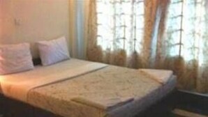 A single bed in a room with a window and curtains. - Golden World Guesthouse (Phnom Penh)