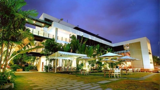 Een modern hotel met terras en een verzorgde tuin.