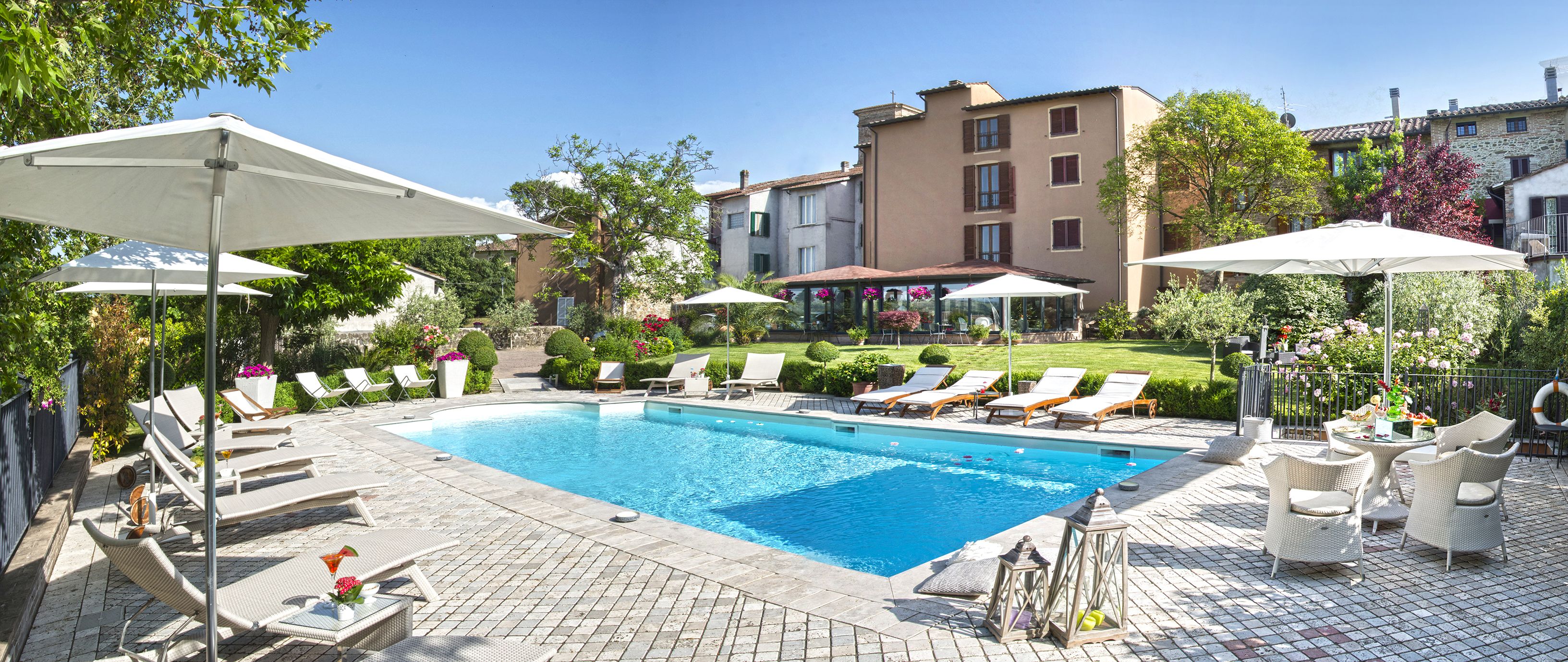 Una piscina al aire libre de temporada, sombrillas