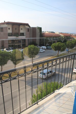 Vista de la calle con un edificio, coches y árboles.
