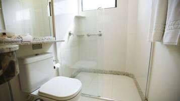 Un baño con inodoro, cabina de ducha y lavabo con espejo.