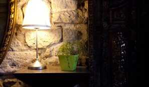 A lamp on a table with a green box containing a plant. - Hôtel Esmeralda (Paris)