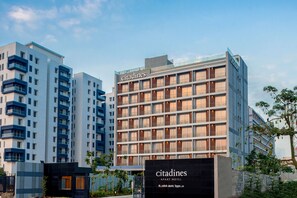 Un hotel-apartamento moderno con varios balcones, un llamativo letrero 'Citadines' y un exterior bien conservado.