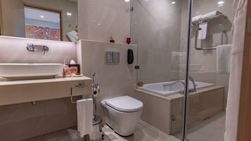 A modern bathroom with a large sink, toilet, and bathtub.