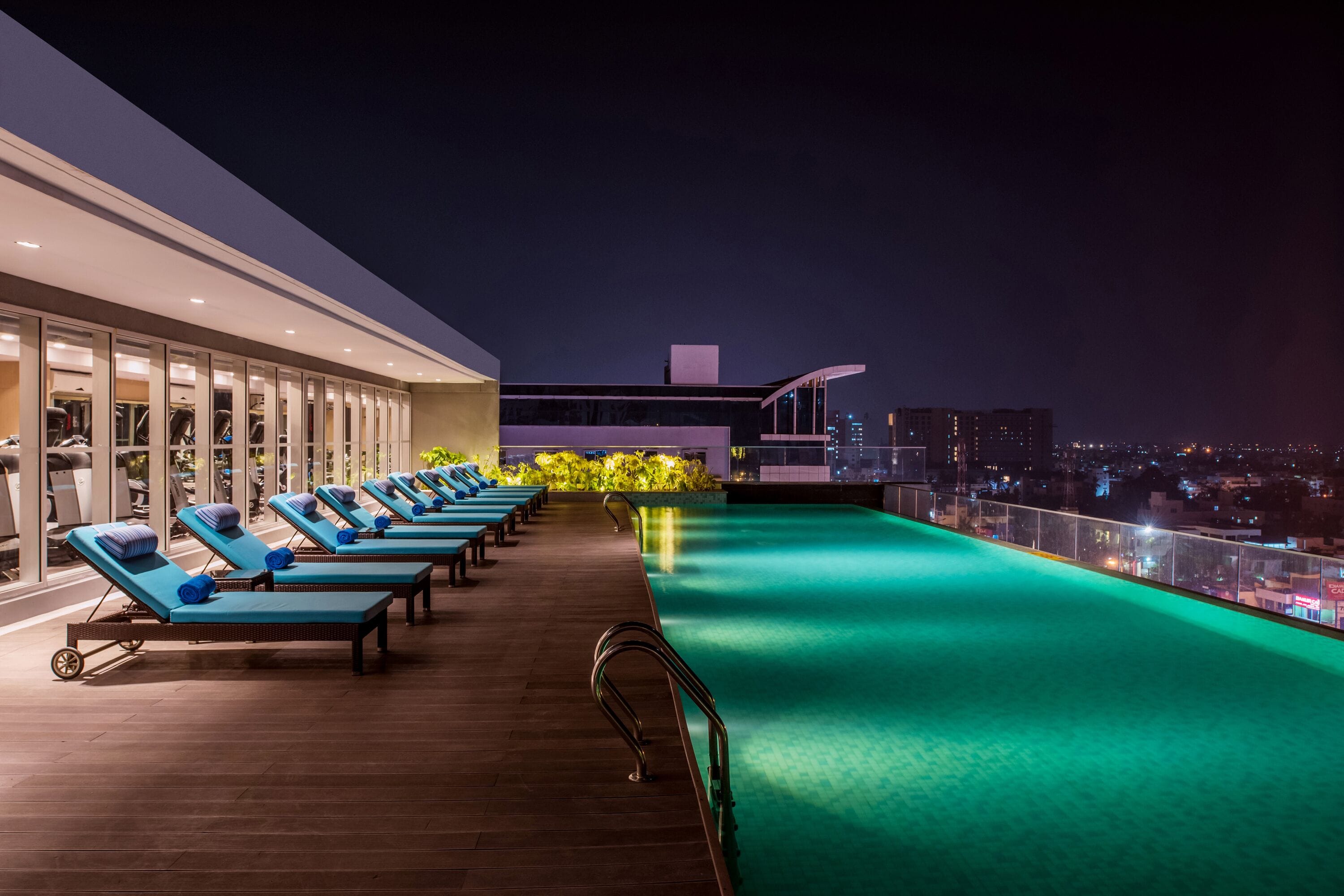 Una piscina al aire libre, sillones reclinables de piscina