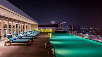 Una piscina al aire libre, sillones reclinables de piscina