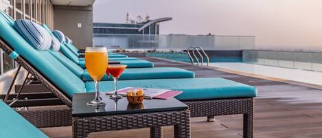 Una piscina al aire libre, sillones reclinables de piscina