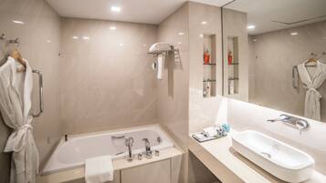 A modern bathroom with a bathtub, a sink, and a large mirror.