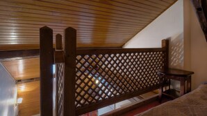 A wooden ceiling with a sloped design, a lattice partition, and a small table. - Hôtel Le Faubourg (Paris)