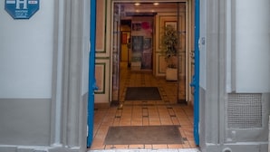 A hotel entrance with a number plaque, a sign indicating it is a tourist hotel, and a tiled floor. - Hôtel Le Faubourg (Paris)