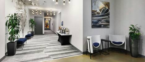A modern reception area with a long hallway, seating area, and a reception desk.