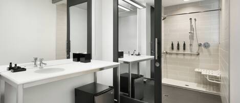 Un baño moderno con dos lavamanos, un espejo y una zona de ducha.