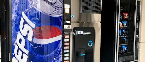 Máquina expendedora con el logotipo de Pepsi, dispensador de agua y otra máquina expendedora con diferentes aperitivos.