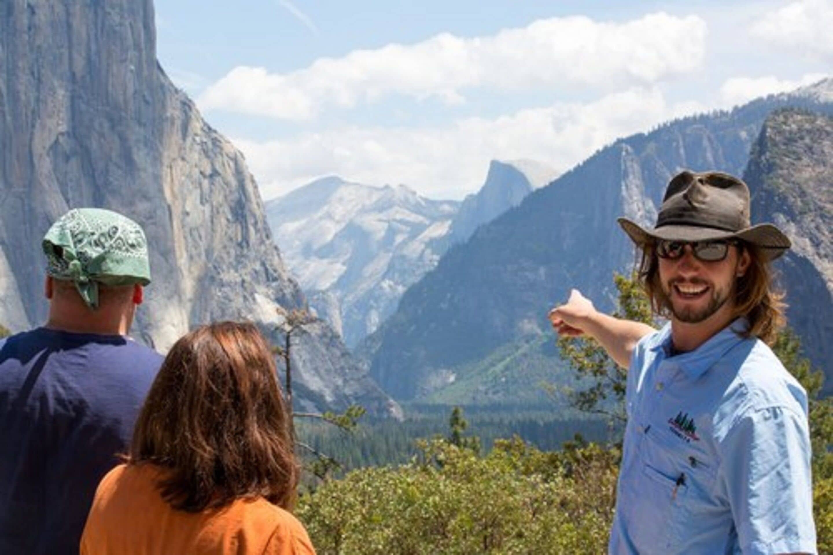 A mountainous landscape with a person pointing towards the view.