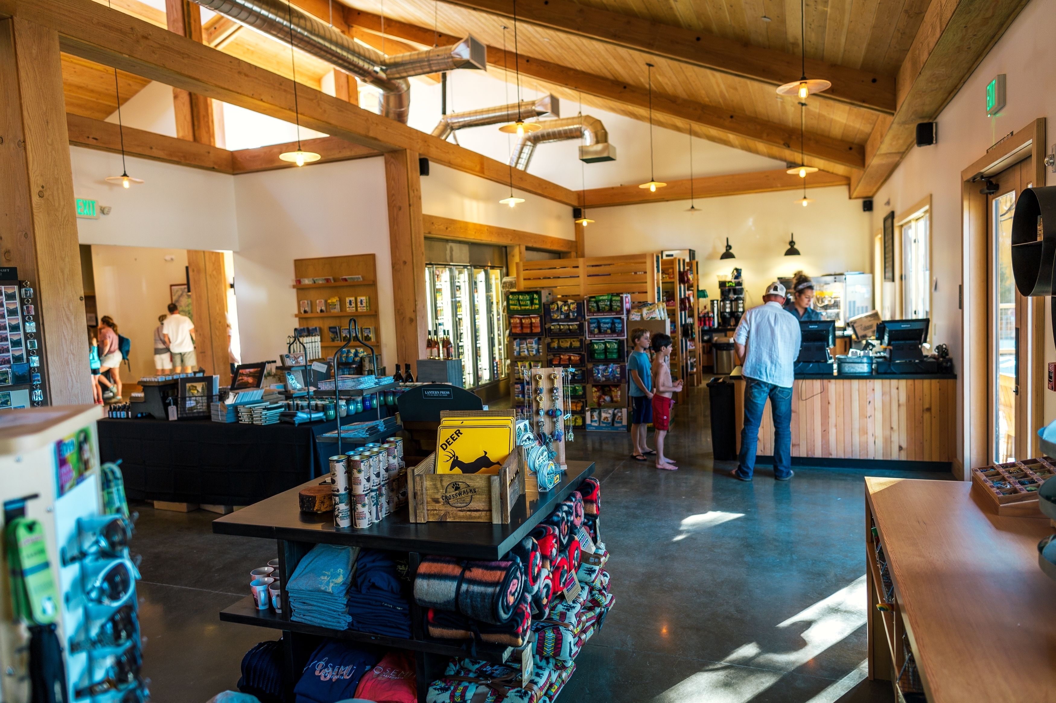 Un magasin spacieux et bien éclairé, avec des poutres en bois et une grande variété de produits exposés, notamment des textiles et des boissons.