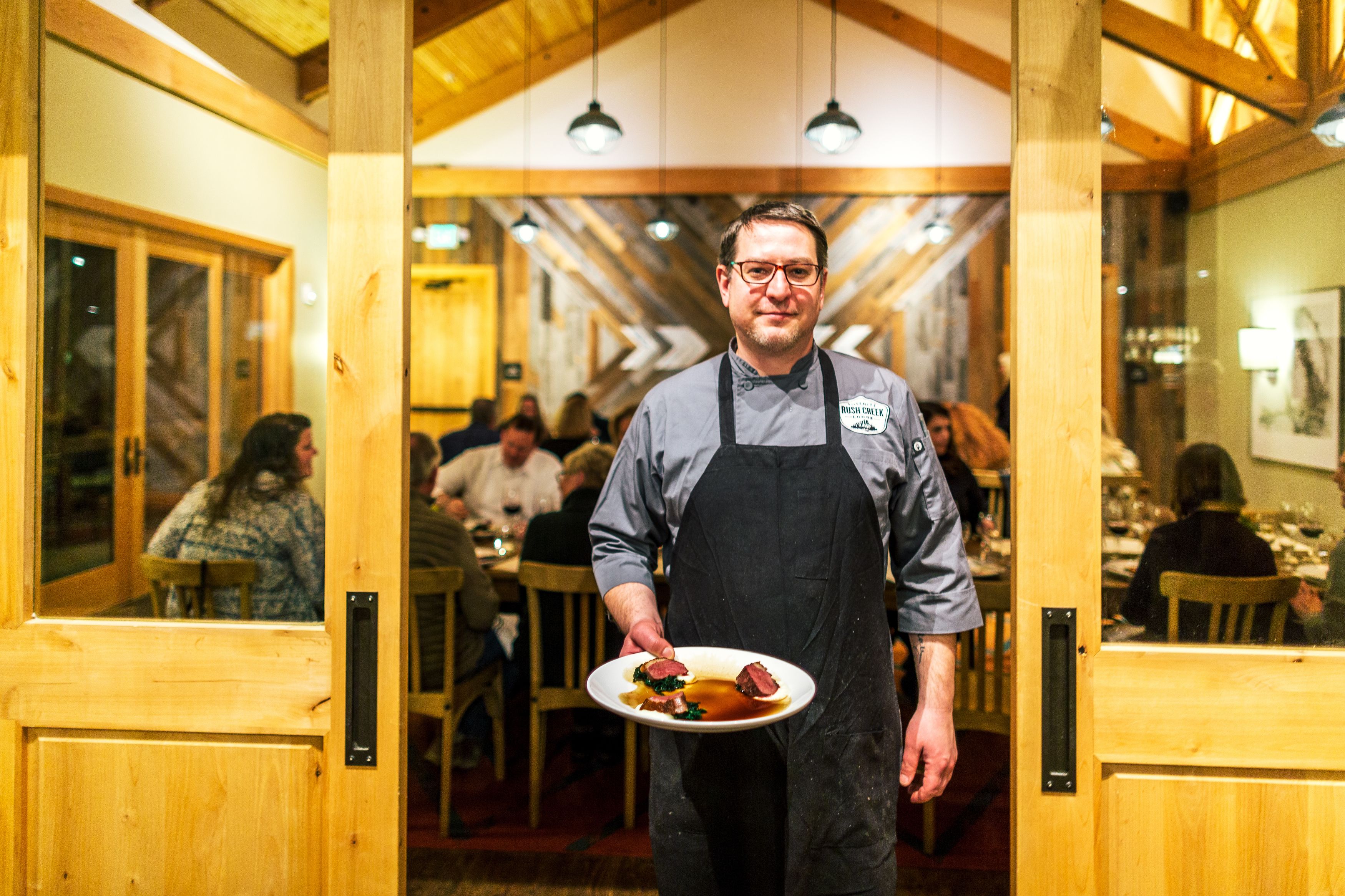 L’intérieur d’un restaurant, avec ses poutres en bois, ses tables et ses clients.