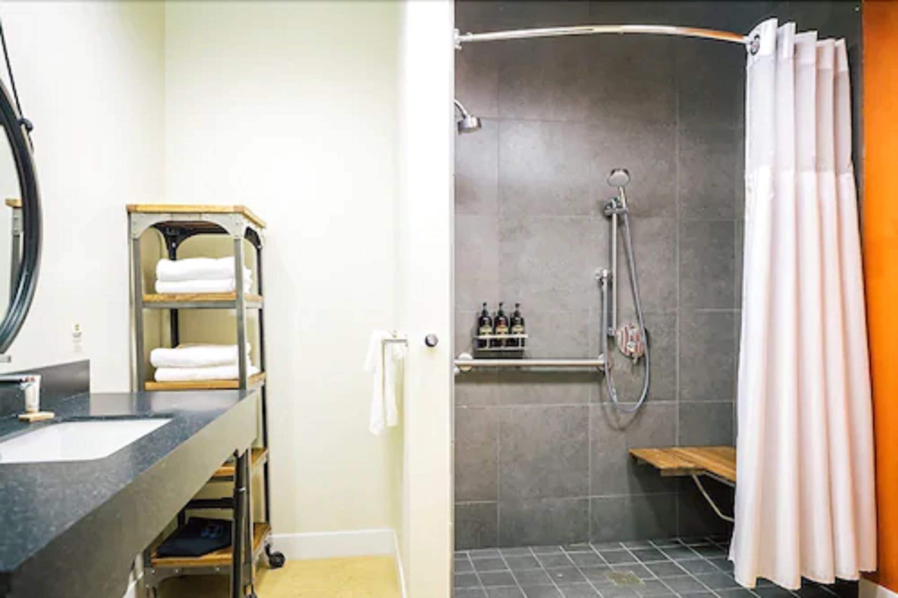 Une salle de bain équipée d’un lavabo, d’un porte-serviettes et d’un espace douche.