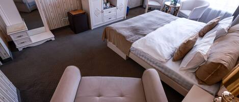 Une chambre d’hôtel avec un lit, un canapé, une télévision, un bureau et une chaise.