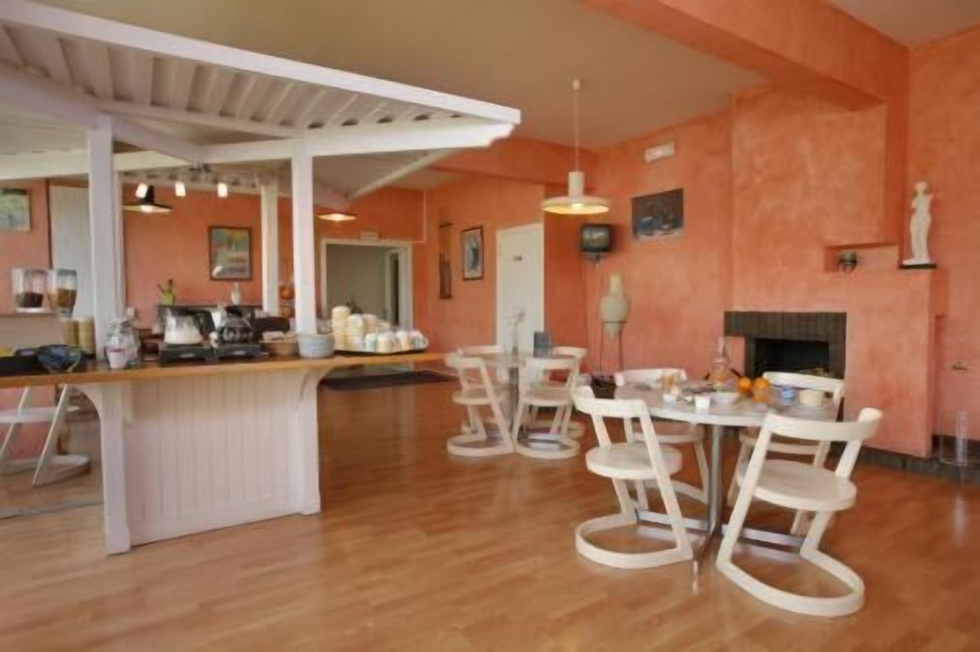 Une cuisine spacieuse avec un îlot central, des chaises blanches et une table à manger.