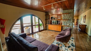 A spacious living area with a curved sofa, a stone accent wall, and a large window providing natural light.