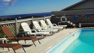 Relax by the pool with ocean views, surrounded by lounge chairs and a lifebuoy.