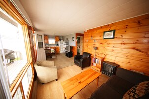 Un acogedor interior de cabaña con sala de estar, comedor y cocina.