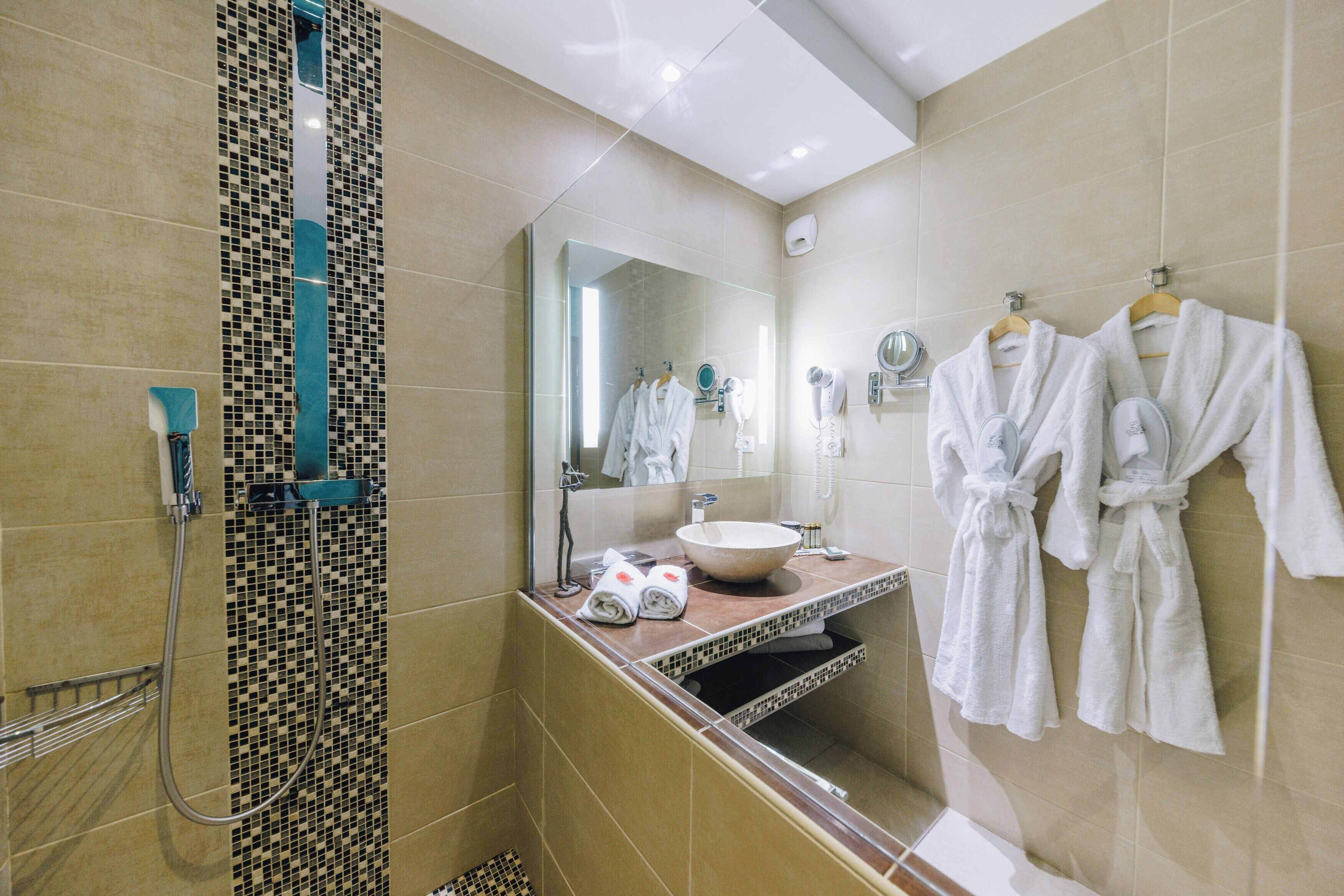 A modern bathroom with a large mirror, a sink, and a shower area.