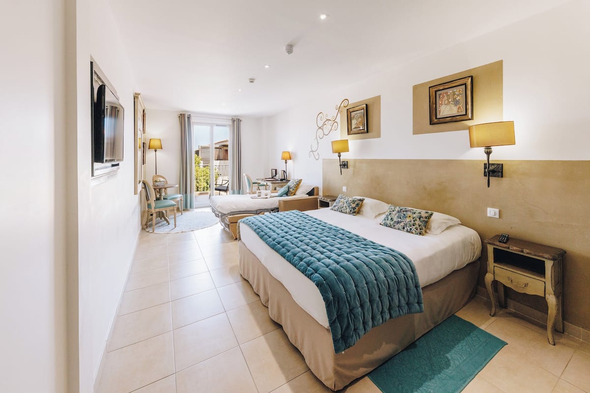 A spacious bedroom with a large bed, bedside tables, a desk, and a chair.