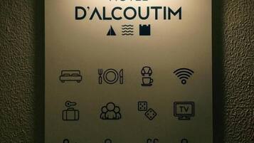 Segnaletica di un hotel con icone che indicano servizi come letto, ristorante, Wi-Fi, televisione e parcheggio.