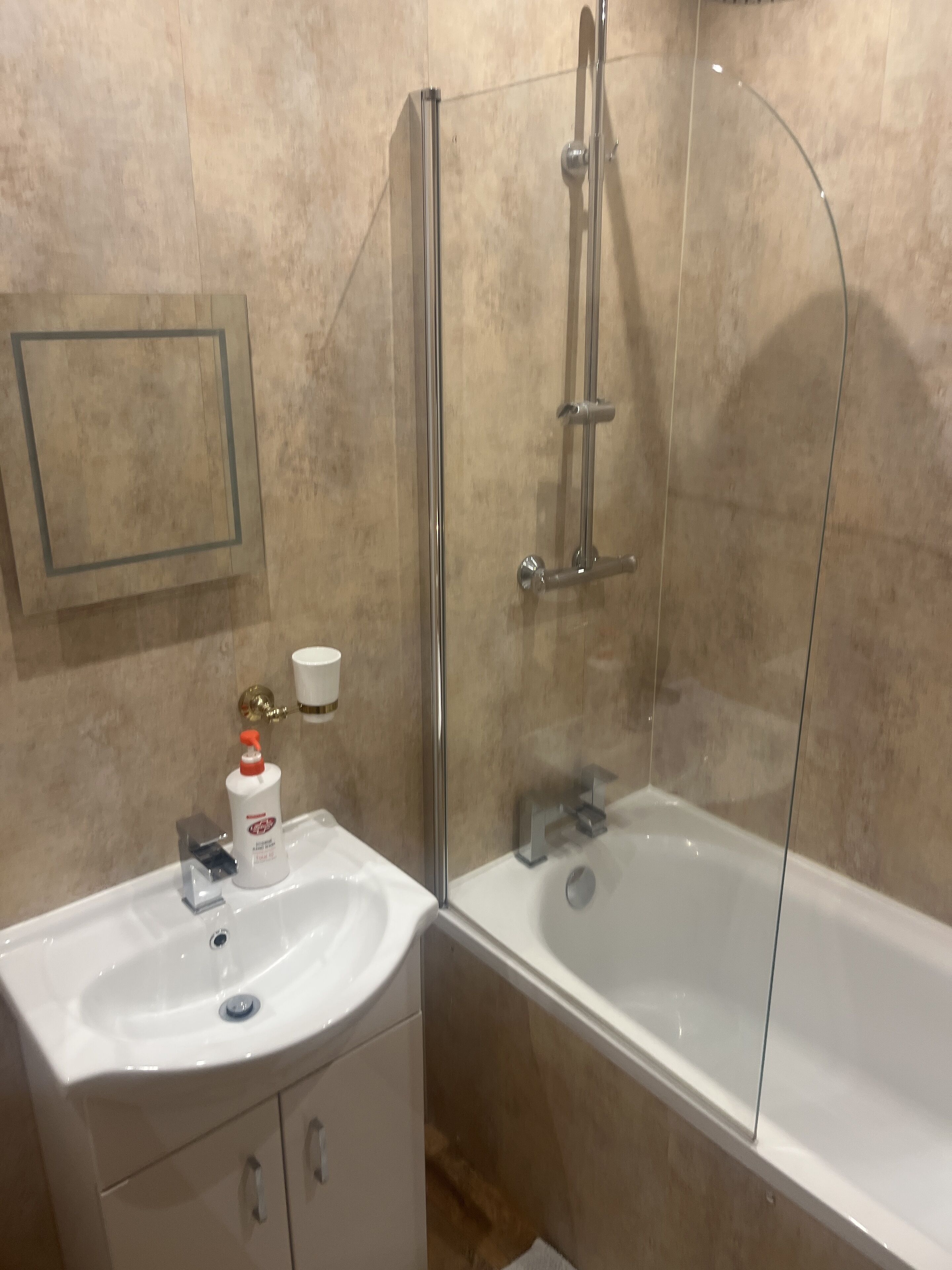 A bathroom with a bathtub, a shower with a glass door, a sink, and a toilet.