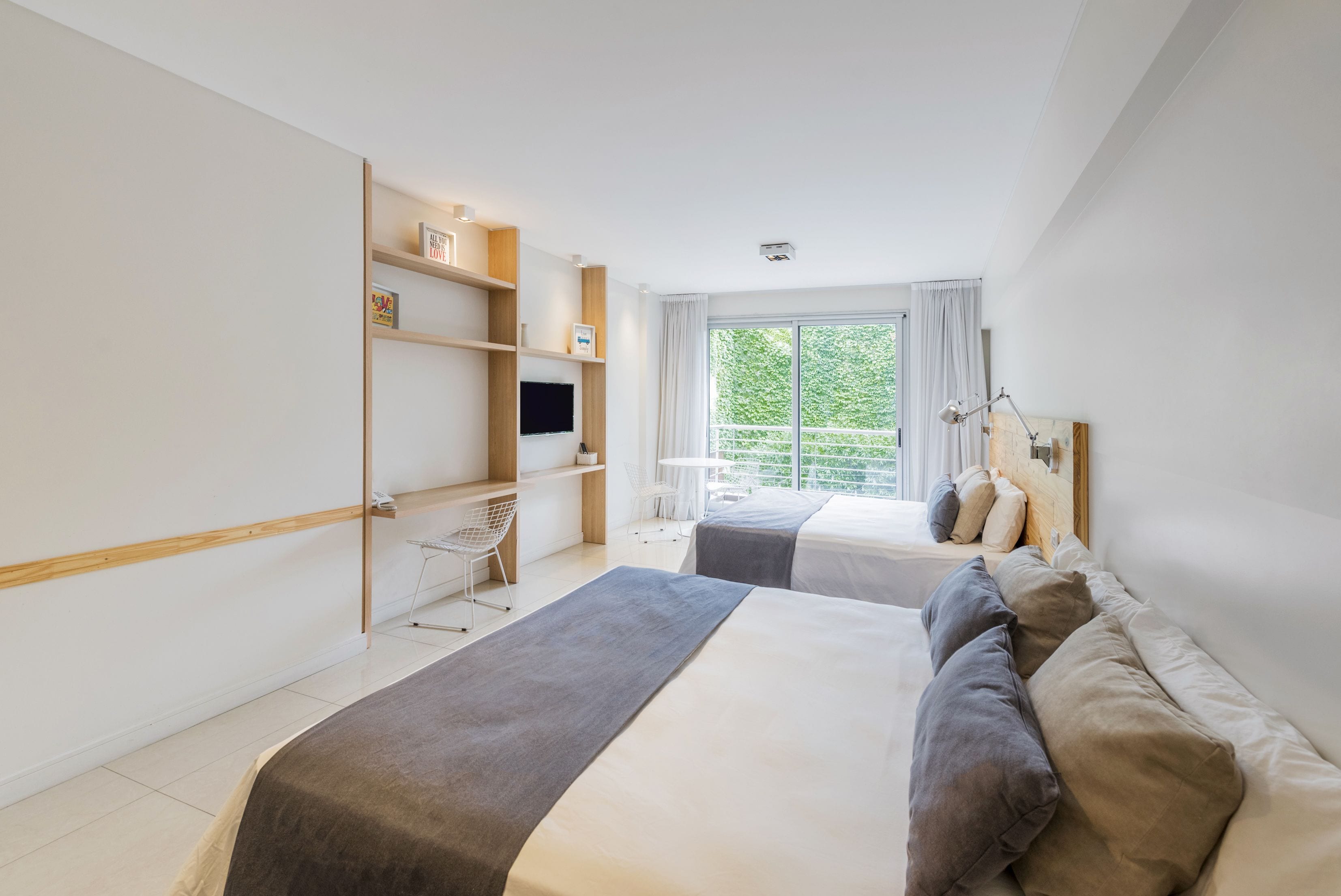 A modern hotel room with a large bed, a desk, and a TV.