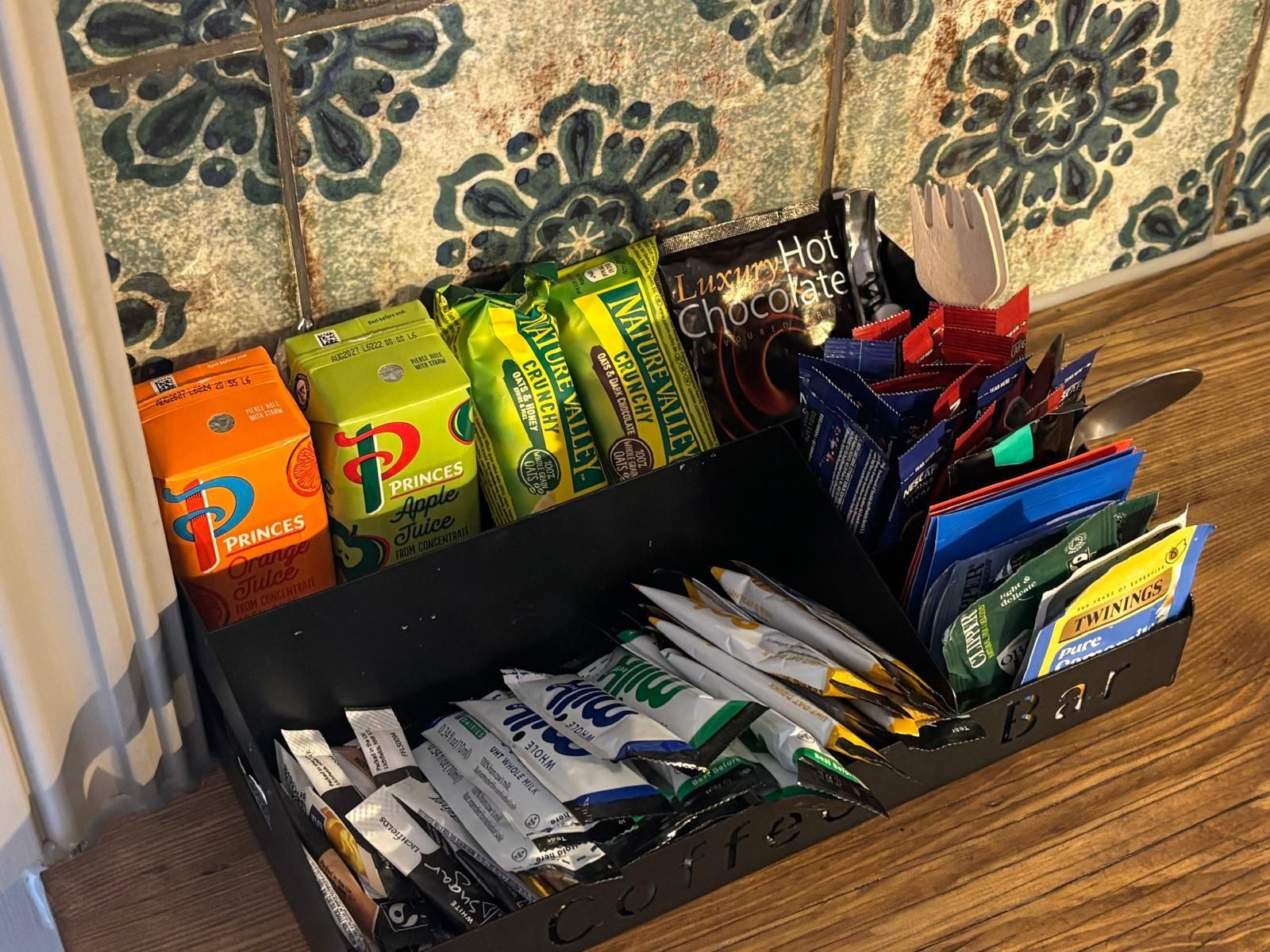A storage area with various food items including juice cartons, chocolate bars, and snacks.