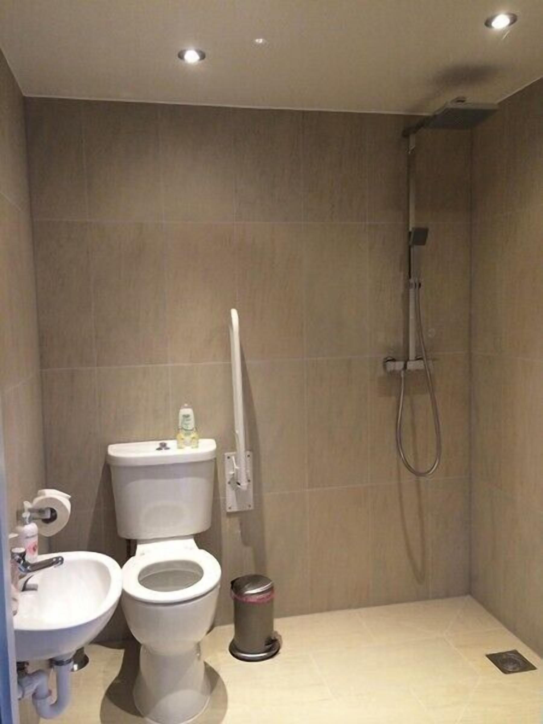 Un baño moderno con inodoro, bidé, lavamanos y ducha.