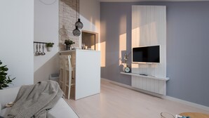 A modern living room with a white sofa, a dining area with a white table, and a mounted TV on a white panel. - BonaMare apartments (Sveti Filip i Jakov)