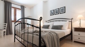 A bedroom with a bed, bedside table, lamp, and a chair. - BonaMare apartments (Sveti Filip i Jakov)