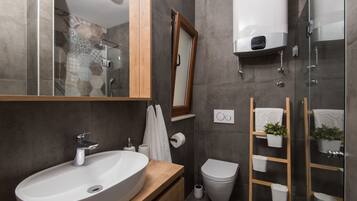 Un baño moderno con lavamanos grande, inodoro y zona de ducha.