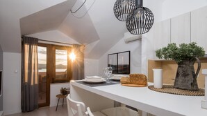 A modern kitchen with a large island, white cabinetry, and a view of the outdoors. - BonaMare apartments (Sveti Filip i Jakov)