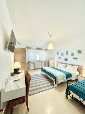 Une chambre d’hôtel comprenant un lit, une table de chevet, une lampe, une chaise, un bureau et un téléviseur.